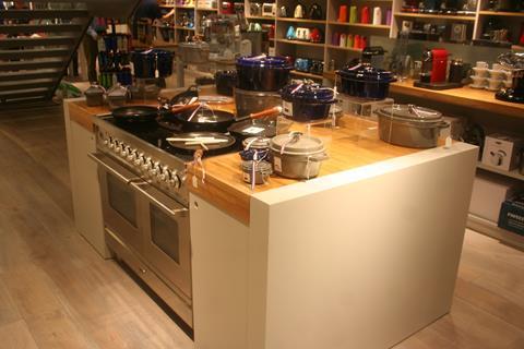 The store opens up at the back with a high ceiling and glass and steel staircase, while strong use of colour blocking makes the merchandising stand out